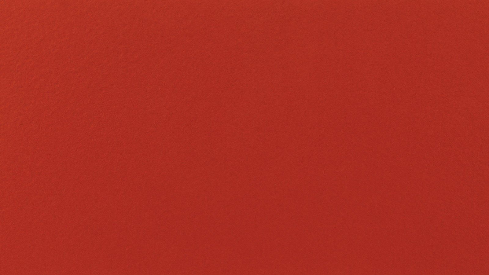 A solid red background with a subtle textured surface.